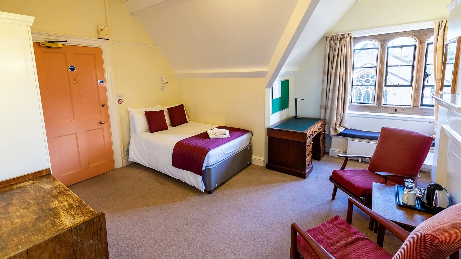 A bedroom with a desk in a college residence